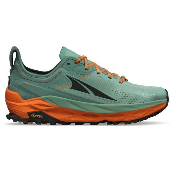 Trailrunschoenen met profielzool op een modderig wandelpad in het bos — grip en bescherming op onverhard terrein.